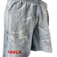 The Purple Brand P504-PIDD All Round Short Water Print Lt Indigo features indigo denim-style, lightly washed shorts with distressed details and a prominent "PURPLE" red text on one leg.