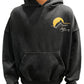 A man wearing a RHUDE AWAKENING HOODIE VTG BLACK with a yellow logo on it.