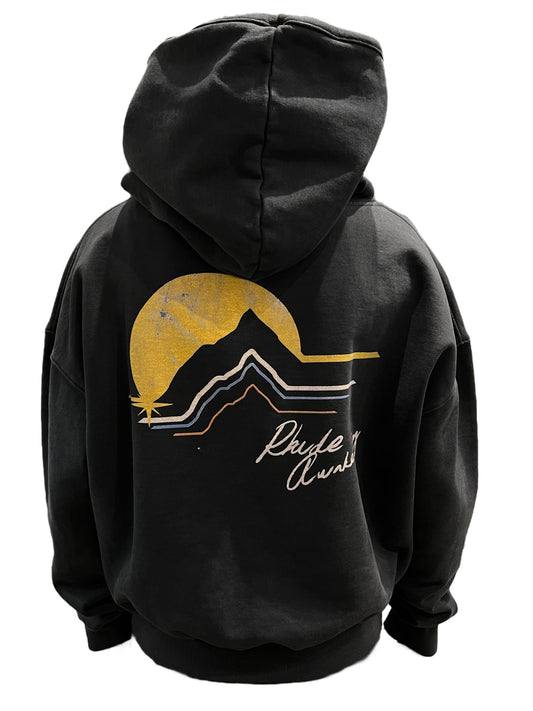The back of a black RHUDE AWAKENING HOODIE VTG BLACK showcases an image of a mountain and a sunset with printed motifs.