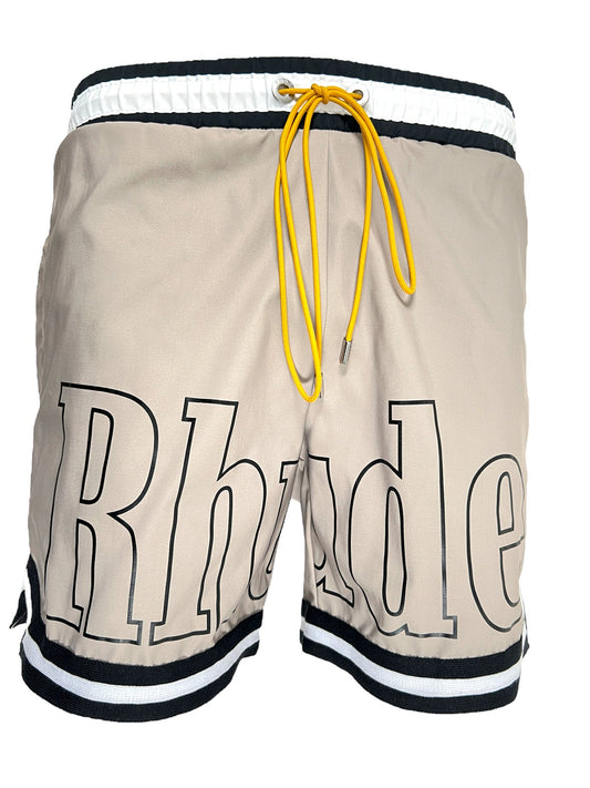 Beige RHUDE basketball swim shorts with the word "rhude" printed on the side and a yellow drawstring.