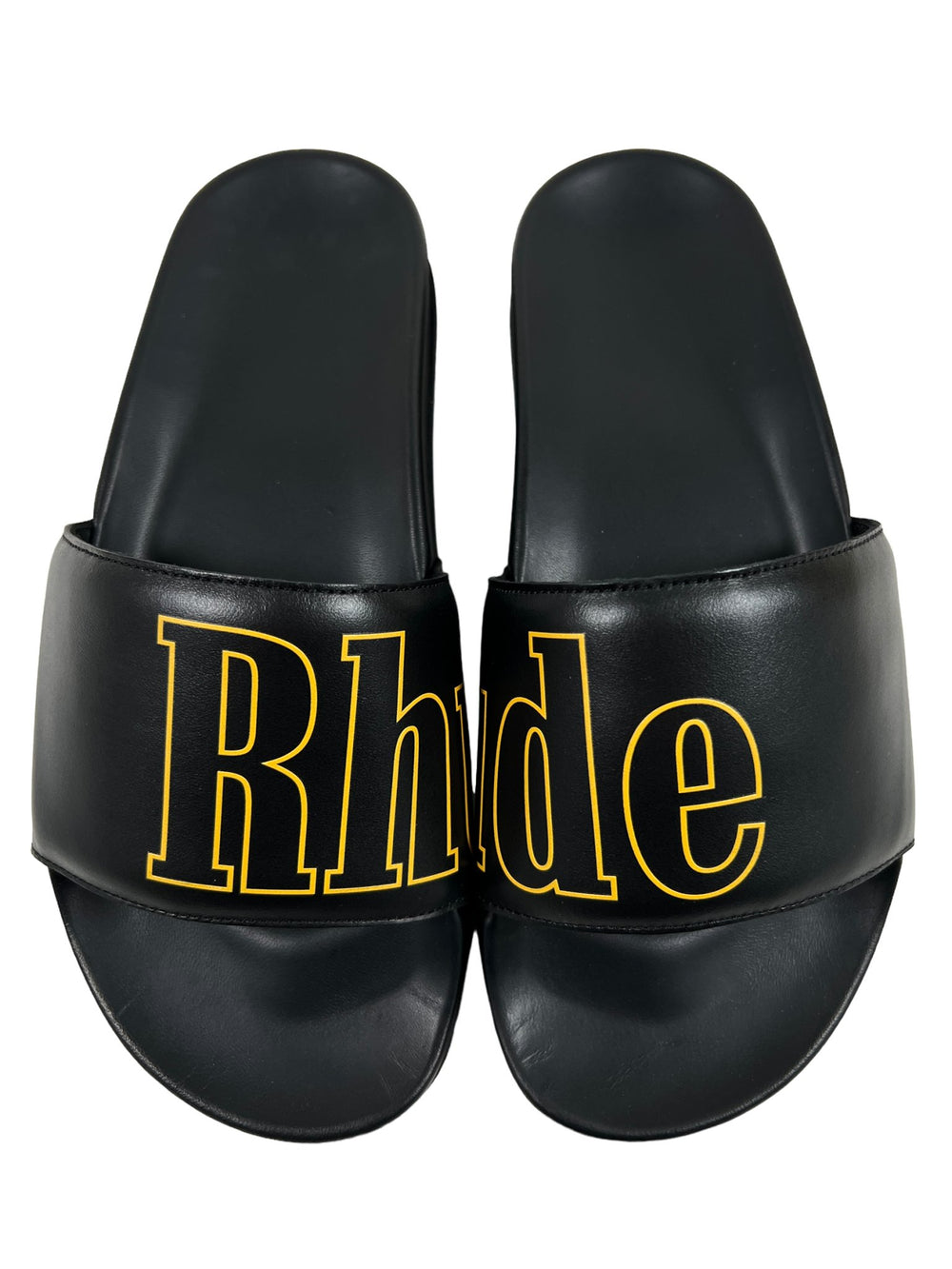 A pair of RHUDE leather slide sandals with the word "rhie" on them, crafted in Italy.