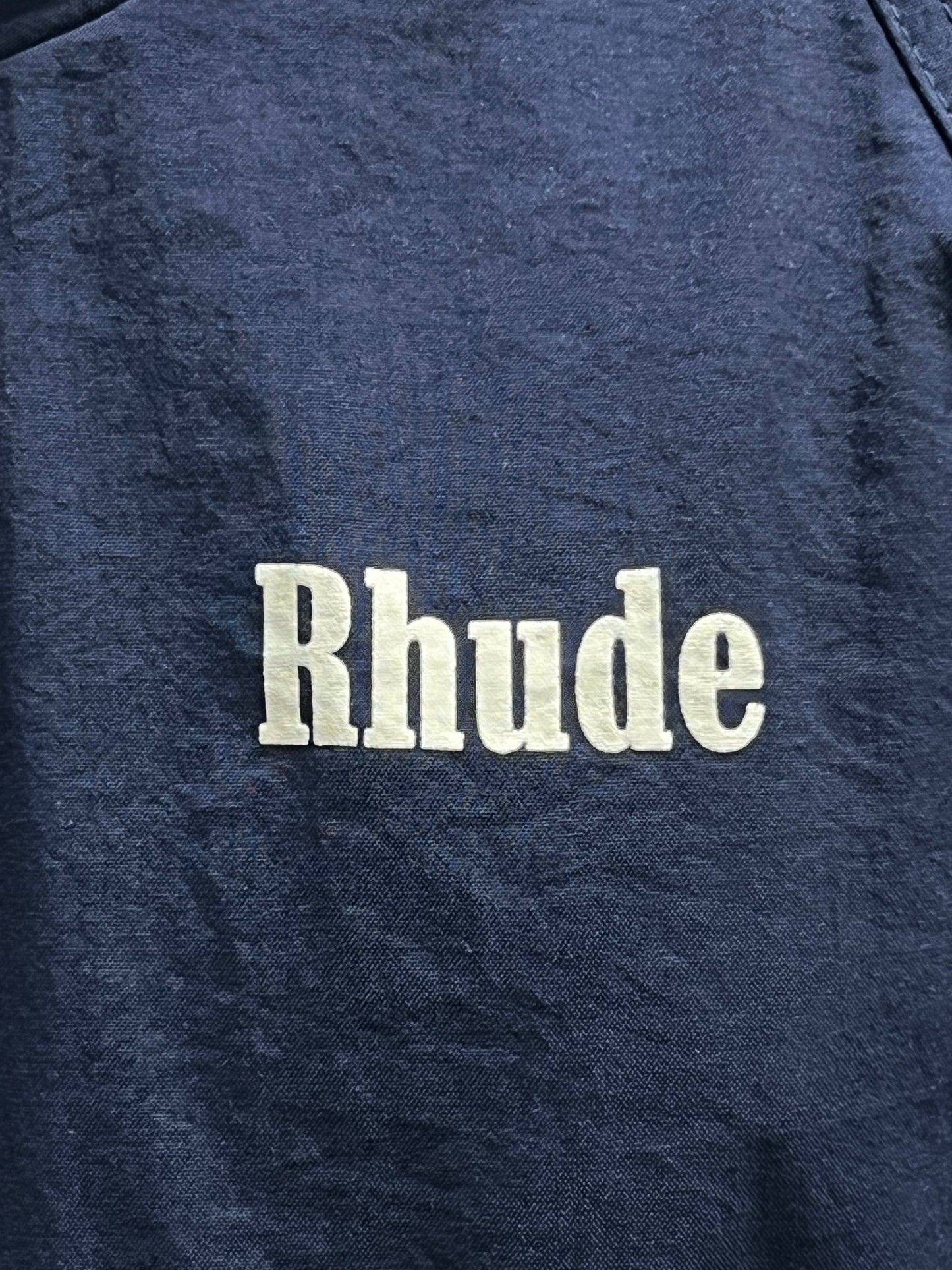 A RHUDE PALM TRACK JACKET NAVY with the RHUDE crest design on it.
