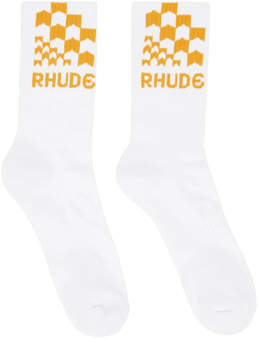 A pair of white, stretch knit calf-high socks with the RHUDE RACING CHECKER SOCK on them.