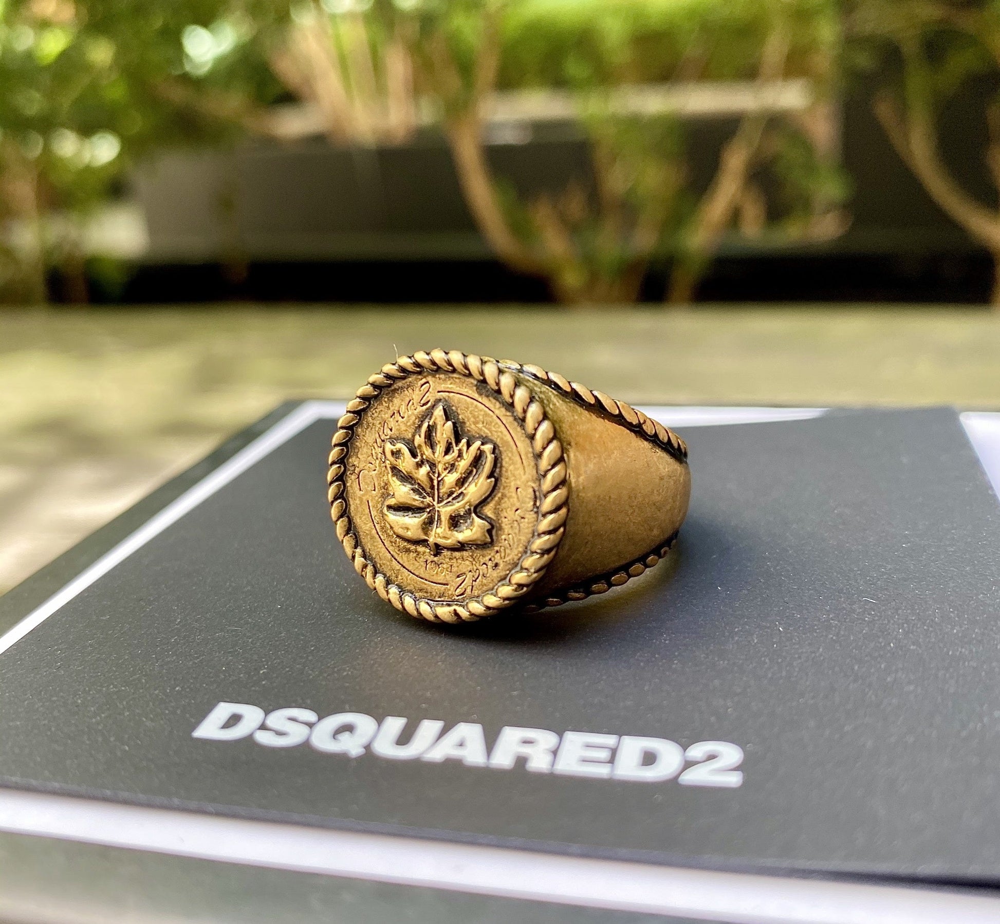 A DSQUARED2 RIM0019 RING-METALLO-ORO ANTICO with a leaf on it.