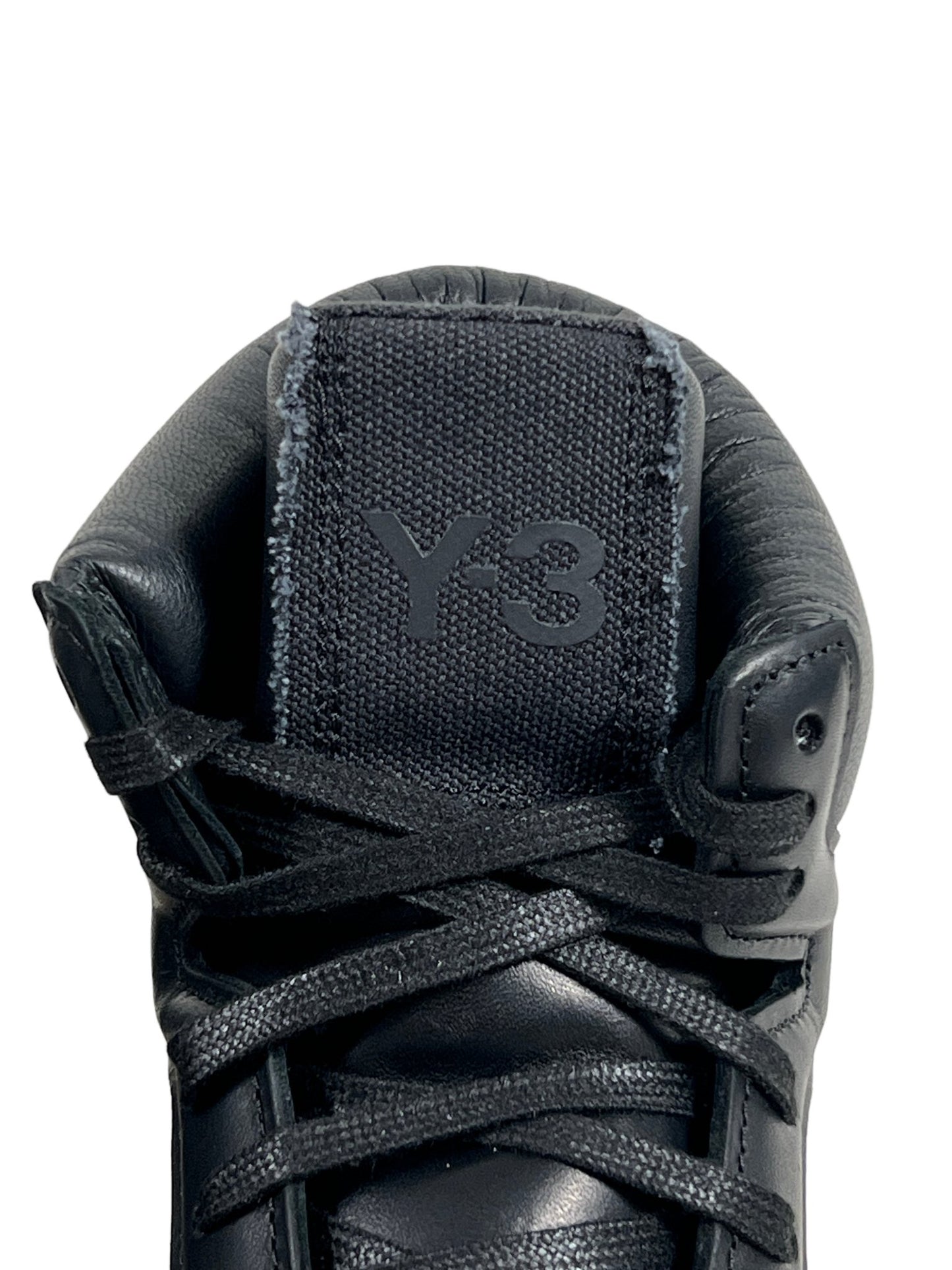 The back of a black, leather ADIDAS x Y-3 sneaker with a logo on it.