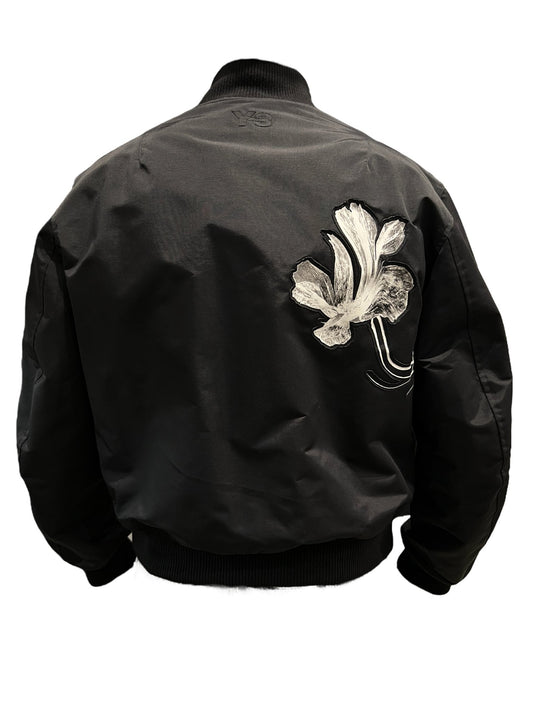 A black Y-3 IR7105 team jacket with a flower embroidered on it and enhanced heat retention.
